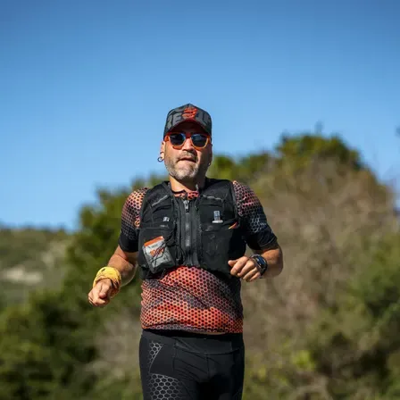 Giannis running an ultramarathon wearing a running vest and bib number 1080